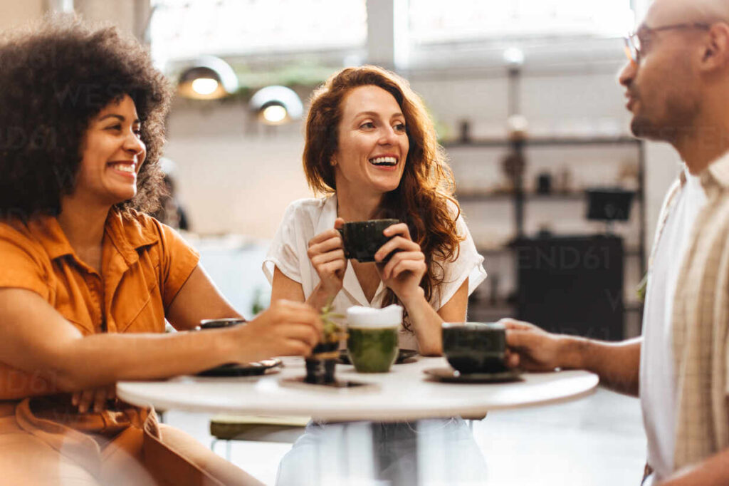 group of friends catch up over coffee in a cozy cafe, taking a break from their busy lives to spend time together and reconnect. happy young people gathering in a relaxed and social environment.