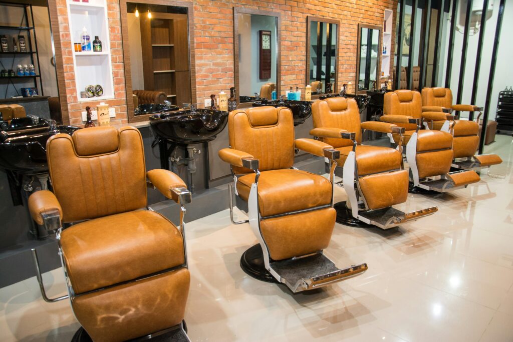 A stylish barbershop interior featuring modern leather chairs and mirrors.